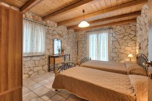 ヴァシリコスにあるVilla Socratesの石壁のベッドルーム1室(ベッド2台付)