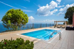 a swimming pool with the ocean in the background at Villa Socrates in Vasilikos
