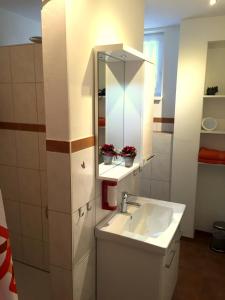 ein Bad mit einem Waschbecken und einem Spiegel in der Unterkunft Gästehaus Dolce Vita in Rust