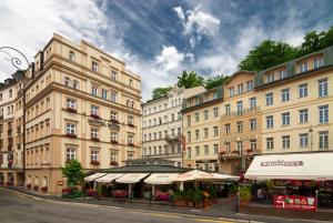a group of buildings with umbrellas in front of a street at Hotel Ruze in Karlovy Vary
