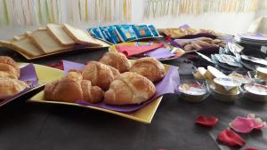 einen Tisch mit Brot, Croissants und anderen Lebensmitteln in der Unterkunft Casa mia in Calatabiano