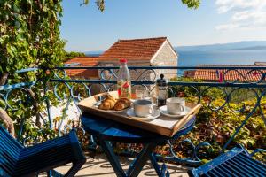 Una mesa con una bandeja de comida y bebidas en un balcón. en Old Town Experience, en Bol