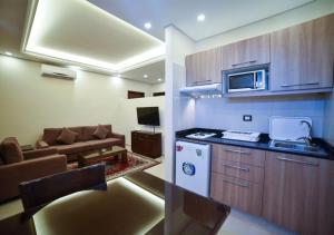 a kitchen and a living room with a couch at Al Jawhara Suites in Beirut