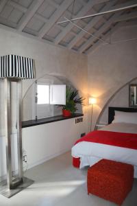 Un dormitorio con una cama roja y blanca y una ventana en Casa Blanco, en Tarifa
