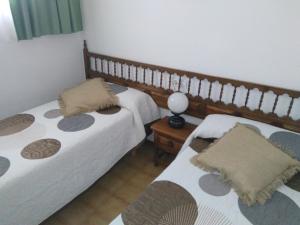 ペニスコラにあるAlpen1 Peñismar IIのベッドルーム1室(ベッド2台、テーブルの上にランプ付)