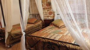 two beds in a room with mosquito nets at Manganos Apartments in Kambos