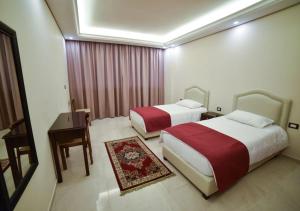 A bed or beds in a room at Al Jawhara Suites