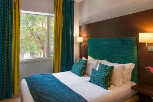 - une chambre avec un lit doté d'une tête de lit bleue et d'une fenêtre dans l'établissement Residenza Flaminio Gaio, à Rome