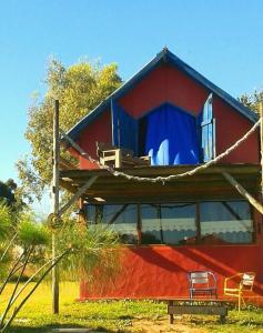 Una casa roja con una cortina azul. en Tacama, en La Pedrera