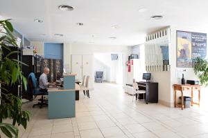 a man sitting at a desk in an office at Hotel Eliseos in M&aacute;laga