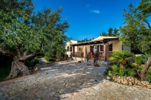 a home with a stone driveway in front of a house at Villa Eden con piscina a Scopello in Castellammare del Golfo