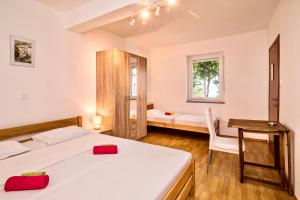 a bedroom with a bed and a desk and a window at Bura in Vrbnik +40 photos