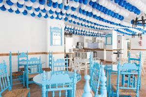 Zimmer mit blauen Stühlen und einer blauen und weißen Decke in der Unterkunft Hotel Eliseos in Málaga