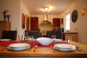 a table with plates and glasses and a bowl on it at Haus Köberle Ummendorf in Biberach-Ummendorf