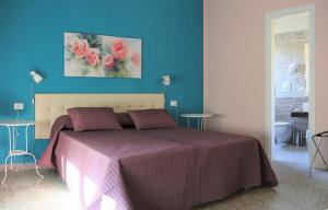1 dormitorio con 1 cama con pared azul en B&B Rosa, en Cosenza
