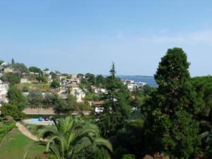 - une vue sur un complexe arboré et une piscine dans l'établissement Two Bed apartment in a gated residence with gardens in Cannes with sea views 865, à Cannes