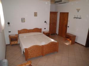 1 dormitorio con 1 cama de madera y 2 mesitas de noche en Agriturismo Mongiorgi "I Salici", en Anzola dell'Emilia