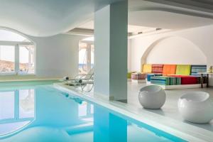 a room with a pool with two white bowls on a table at Casa Del Mar - Small Luxury Hotels of the World in Agios Ioannis Mykonos