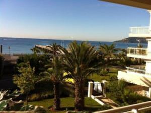 een uitzicht op een resort met palmbomen en de oceaan bij Stunning 2 Bed Apt on the seafront of Cannes in a high class secure building with swimming pool 463 in Cannes