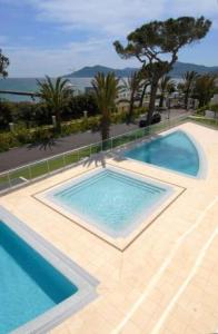 カンヌにあるStunning 2 Bed, 2 Bath Apt on the Cannes sea front has swimming pool and is a secure modern building 464のパティオ(青い水のスイミングプール付)