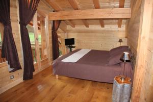 een slaapkamer met een bed in een houten hut bij L Aube Claire in Morzine