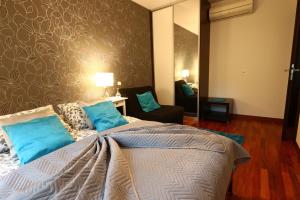 a bedroom with a large bed with blue pillows at Apartament Turkus in Jurata