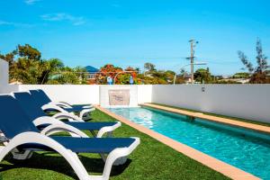 a row of blue chairs sitting next to a swimming pool at Scarborough Beach Resort Brisbane in Scarborough