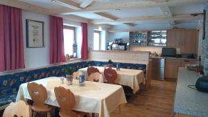 a restaurant with a table and chairs and a kitchen at Gasthof Leiter´s Hoamatl in Umhausen