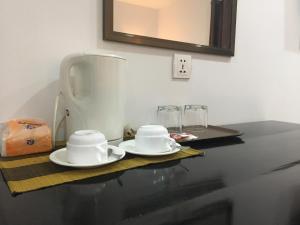 due piatti bianchi seduti su un tavolo con piano di lavoro di Green Life Cottage a Siem Reap