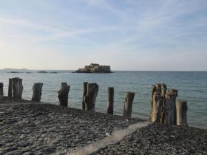 een groep houten palen op de oever van een waterlichaam bij Ker Annick in Saint-Malo