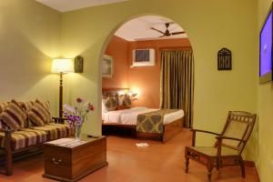 pokój hotelowy z łóżkiem i kanapą w obiekcie Pride Sun Village Resort & Spa w mieście Baga