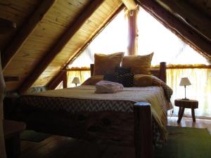 una camera con un letto in una baita di tronchi di Paraiso Bariloche a San Carlos de Bariloche