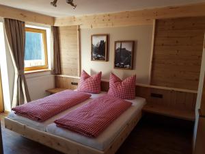 a bedroom with two beds with red pillows at Gasthof Leiter´s Hoamatl in Umhausen