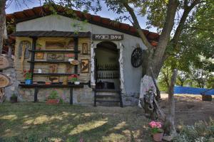 um pequeno barracão com uma placa que lê barra de erva em Etno Kompleks Kapetan Mišin breg em Donji Milanovac