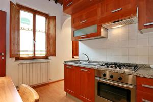 a kitchen with wooden cabinets and a stove top oven at Casa Alberto in Lucca