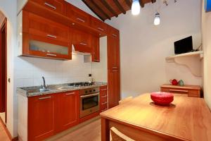 una cocina con una mesa de madera con un cuenco rojo. en Casa Alberto, en Lucca