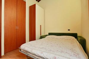 1 dormitorio con 1 cama y armario de madera en Casa Alberto, en Lucca