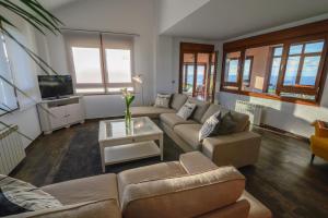 a living room with a couch and a tv at Mirador del Mar in Oviñana