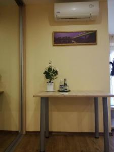 a table in a room with a plant on it at Apartamentai Klonio g. in Druskininkai