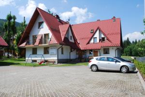 un coche blanco estacionado frente a una casa en Biały Dworek, en Zakopane