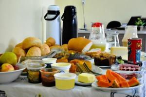 a table with many different types of food on it at Pousada Aparados in Cambará