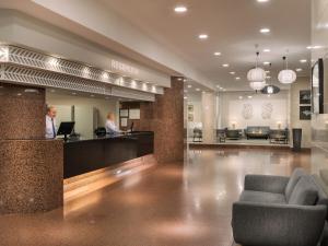 a lobby with two people sitting at a counter at Relaxia Beverly Park in Playa del Ingles