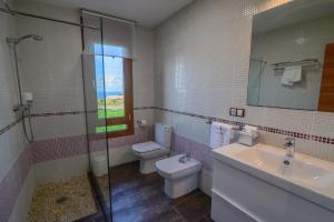 a bathroom with a toilet and a sink and a shower at Mirador del Mar in Oviñana +48 photos