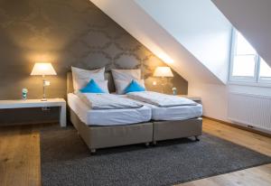 a bedroom with a large bed with blue pillows at Helvetia Suites in Düsseldorf