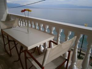 a table and chairs on a balcony overlooking the ocean at Antonios Rooms in Akrata