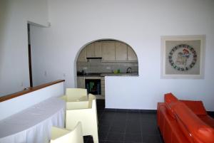 sala de estar con paredes blancas y sofá rojo en Villa Teresa, en Benitachell