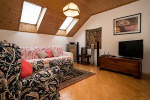 a living room with a couch and a flat screen tv at Villa Sissi in Laives