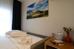 1 dormitorio con 1 cama con mesa y una foto en la pared en Pensiunea La Broscuta en Cîmpia Turzii