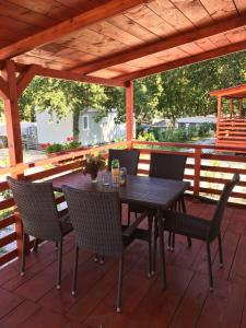 a wooden table and chairs on a wooden deck at Mobile Homes Comfort ELBA Zelena Laguna in Poreč
