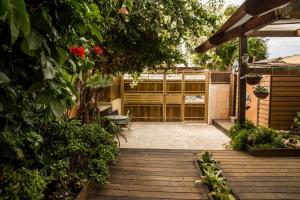 a garden with a wooden walkway with plants and flowers at Passion Fruit Apartment in Ashkelon